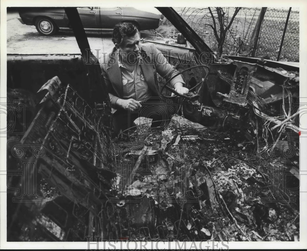 1979 James Hayden, Owner of Vulcan Taxicab Company, in burned cab - Historic Images