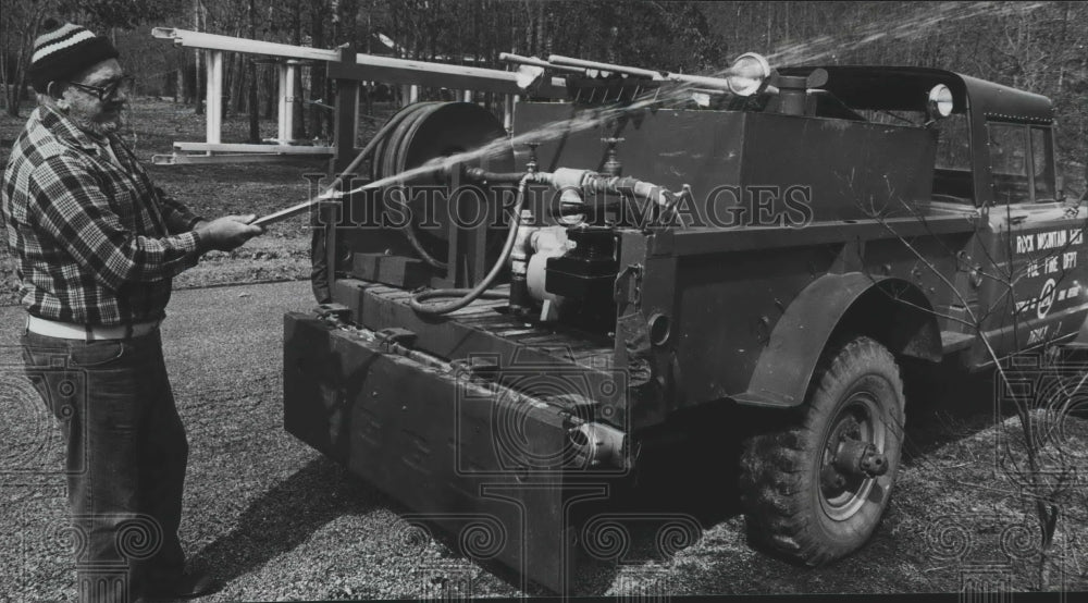 1981, Volunteer Hal Deutschman tests water pressure on fire truck - Historic Images