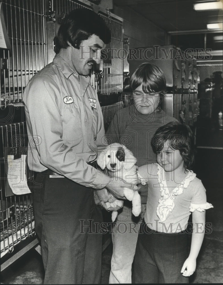 1975, Humane Society&#39;s Ron Kinglsey helps family select puppy - Historic Images