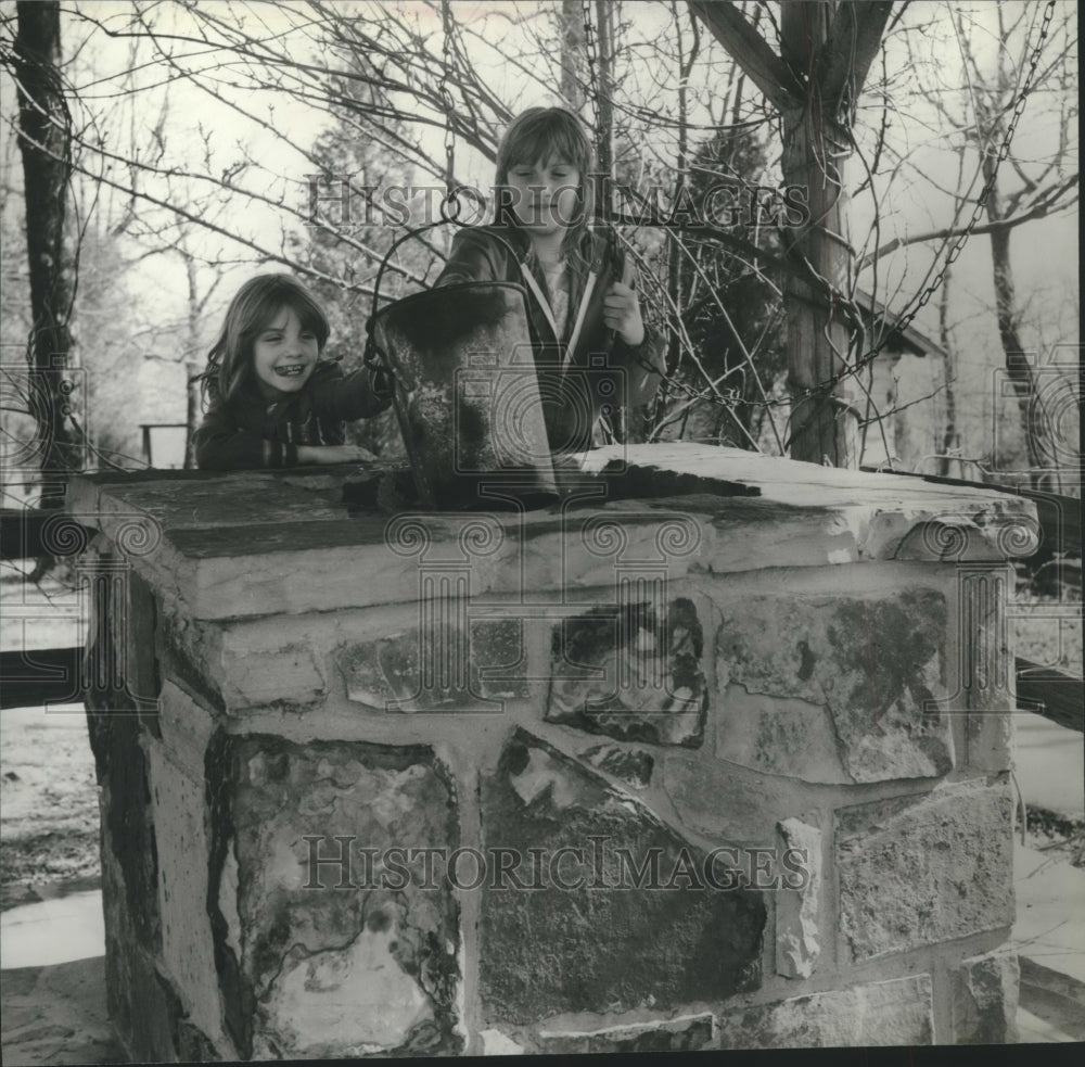 1980 Tracy, left, and Tina Fry examine old well at Pioneer Village - Historic Images