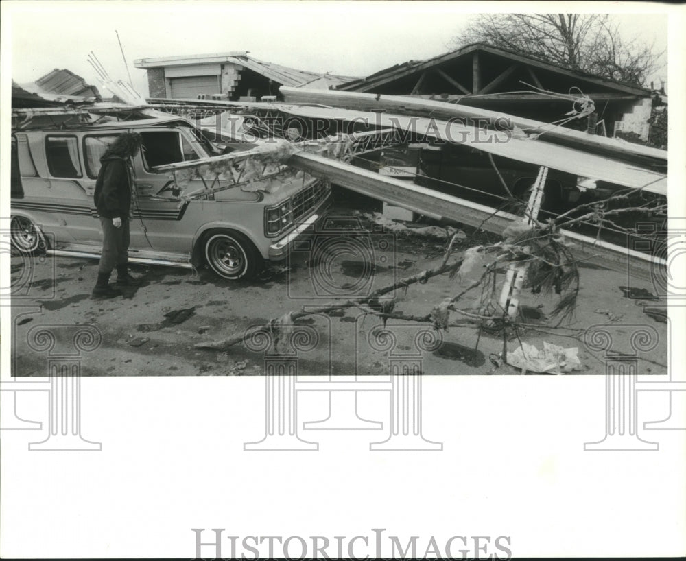 1989 Press Photo Cheryl Gilbert looks at van damaged by tornado in Talledega, AL - Historic Images