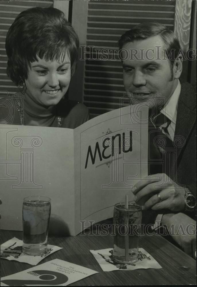 1973, Mr. &amp; Mrs. Ashby Boulware looking at menu in restaurant - Historic Images