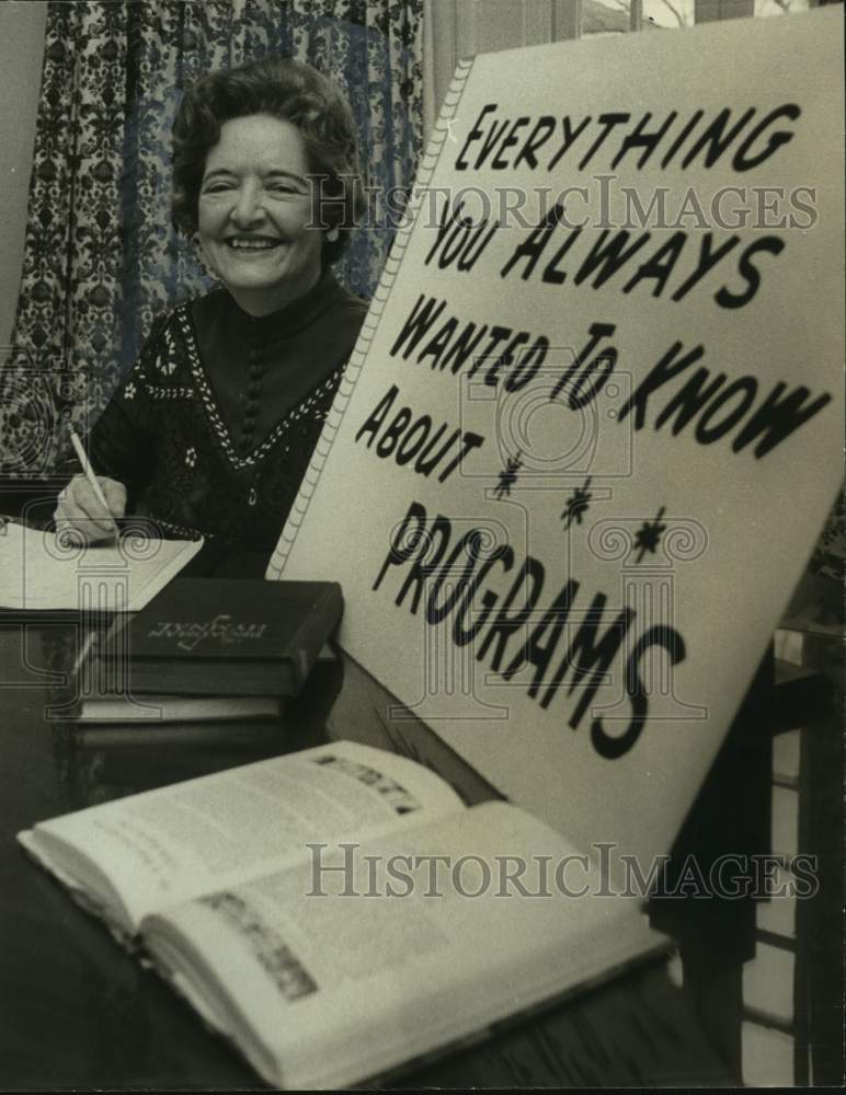 1973, Mrs. B.P. Bowden promoting programs, at desk with sign - Historic Images