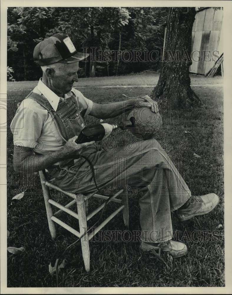 1991 Press Photo James Swann drilling hole in gourd in yard - abna43239 - Historic Images