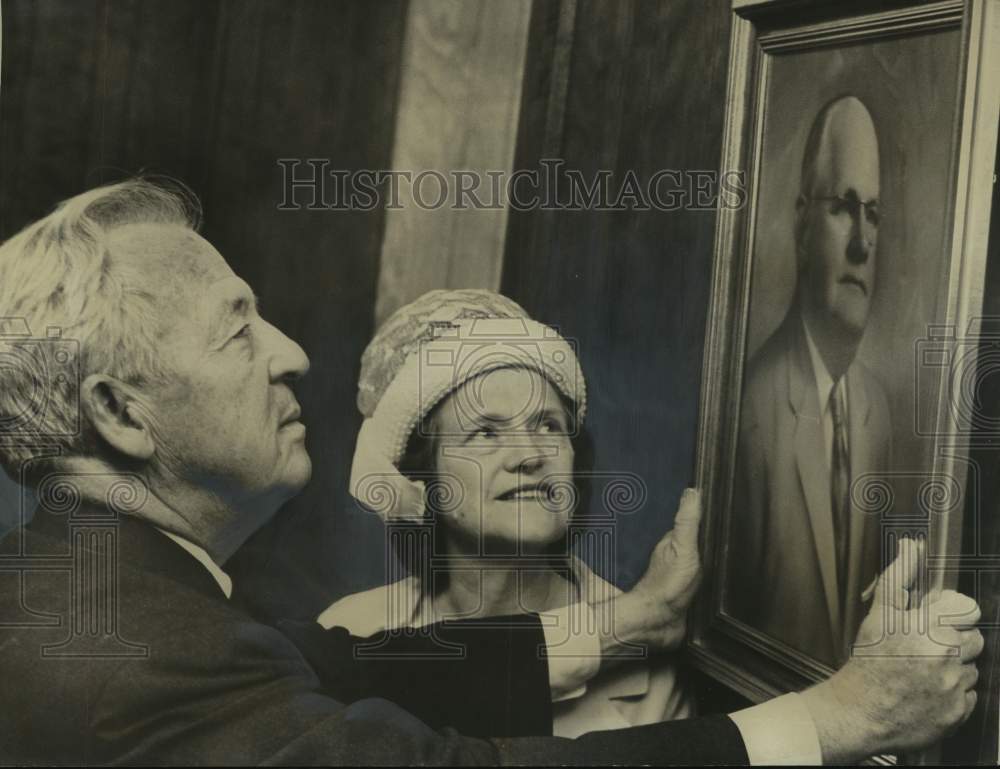 1965, Mrs. George H. Boyd watches as portrait of her husband is hung - Historic Images