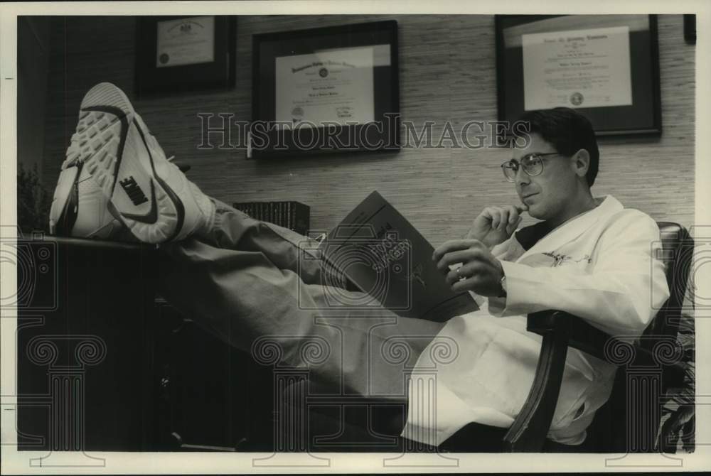 1990 Press Photo Dr. Robert Russell Reading in a Chair - abna44128 - Historic Images