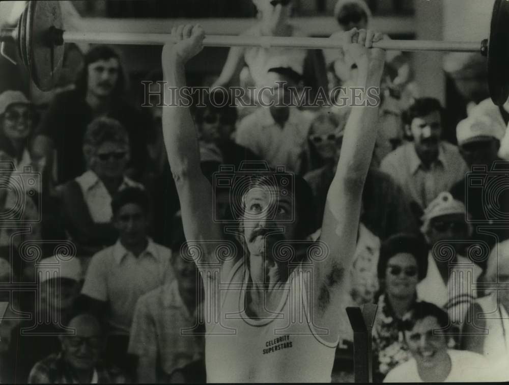 1975 Press Photo George Lindsey, Comedian, lifting weight in Celebrity Superstar - Historic Images