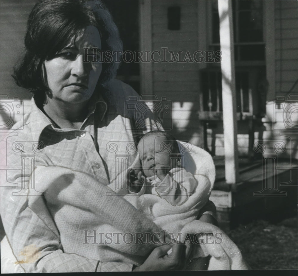 1980, Mrs. Ruby Tribble holds baby of Murder Victim in front of Home - Historic Images