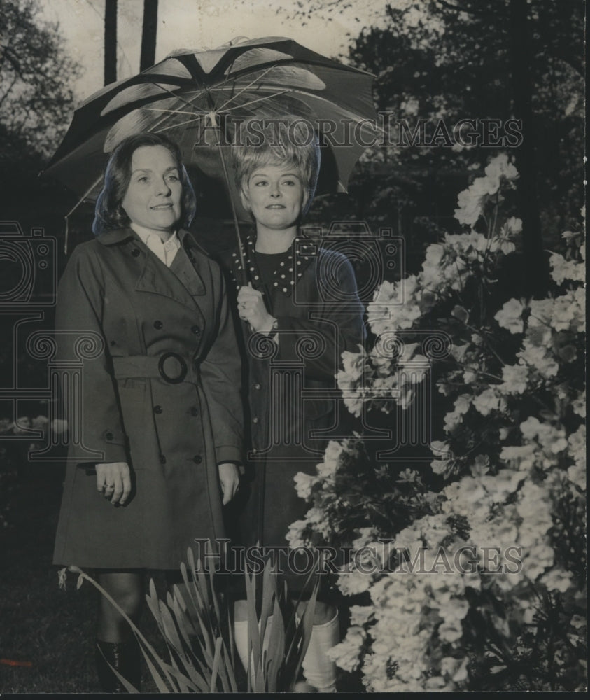 1972, Mrs. H. H. Brush, Mrs. Roy Caffee under Umbrella near Flowers - Historic Images