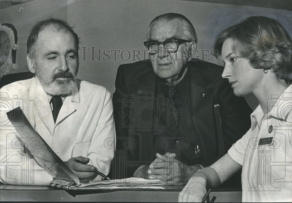 1976 Doctor and Nurse Brief Minister on Patient&#39;s Condition, Alabama - Historic Images