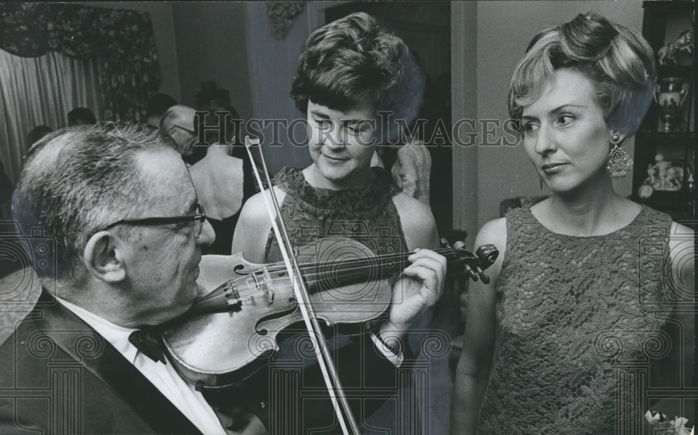 1967 Press Photo Guests at Auction Party - Women Listen to Man Play Violin - Historic Images