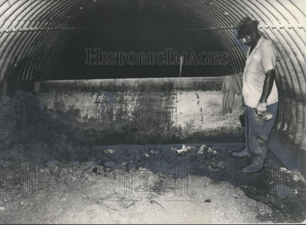 1977, Unidentified workman inspects &quot;dam&quot; near Belwood area, Alabama - Historic Images