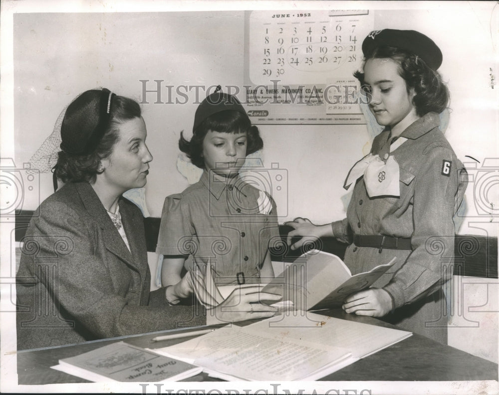 1952, Mrs. Lamar Triplett with Girl Scout & Brownie looking at book - Historic Images