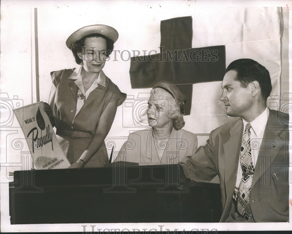 1951, Mrs. B. H. Johnson holds Red Cross poster with Mrs. D. Norris - Historic Images