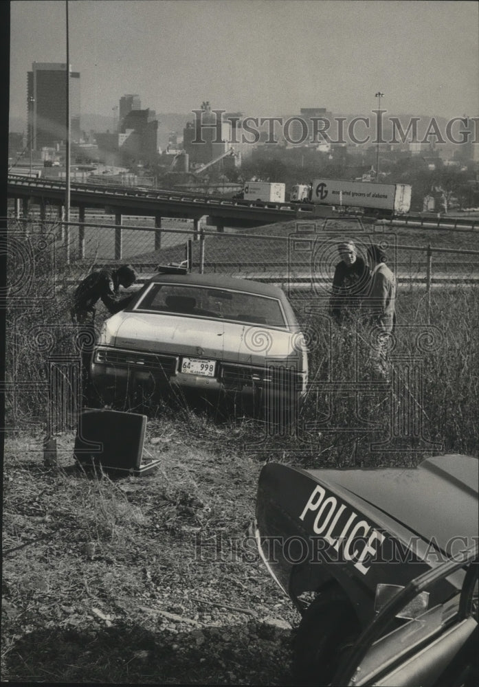 1974 Police check over car downtown after tip from residents - Historic Images