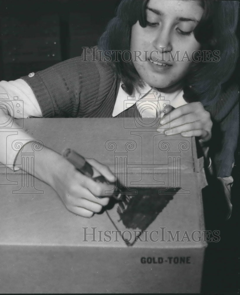 1974 Diane Coon adds relief symbol painted on each box, Guatemala - Historic Images