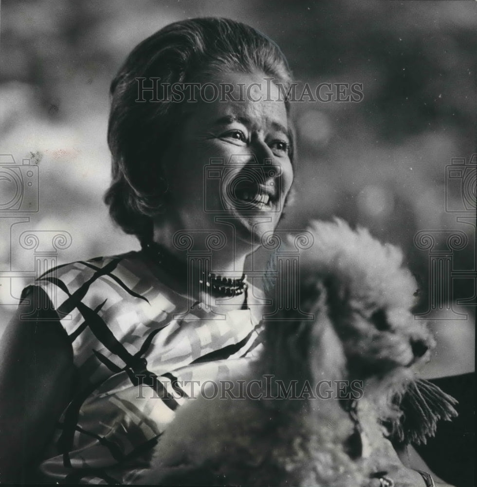 1966, Mrs. G. T. Nelson relaxes with white poodle dog Mingo - Historic Images