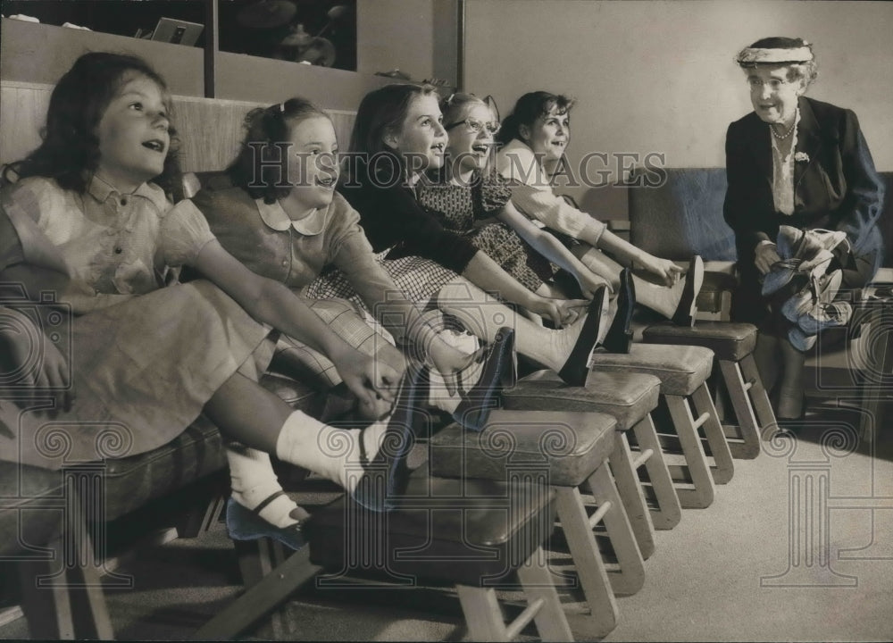 1958, Mrs. Minnie Mowry with Children trying on Easter Shoes - Historic Images