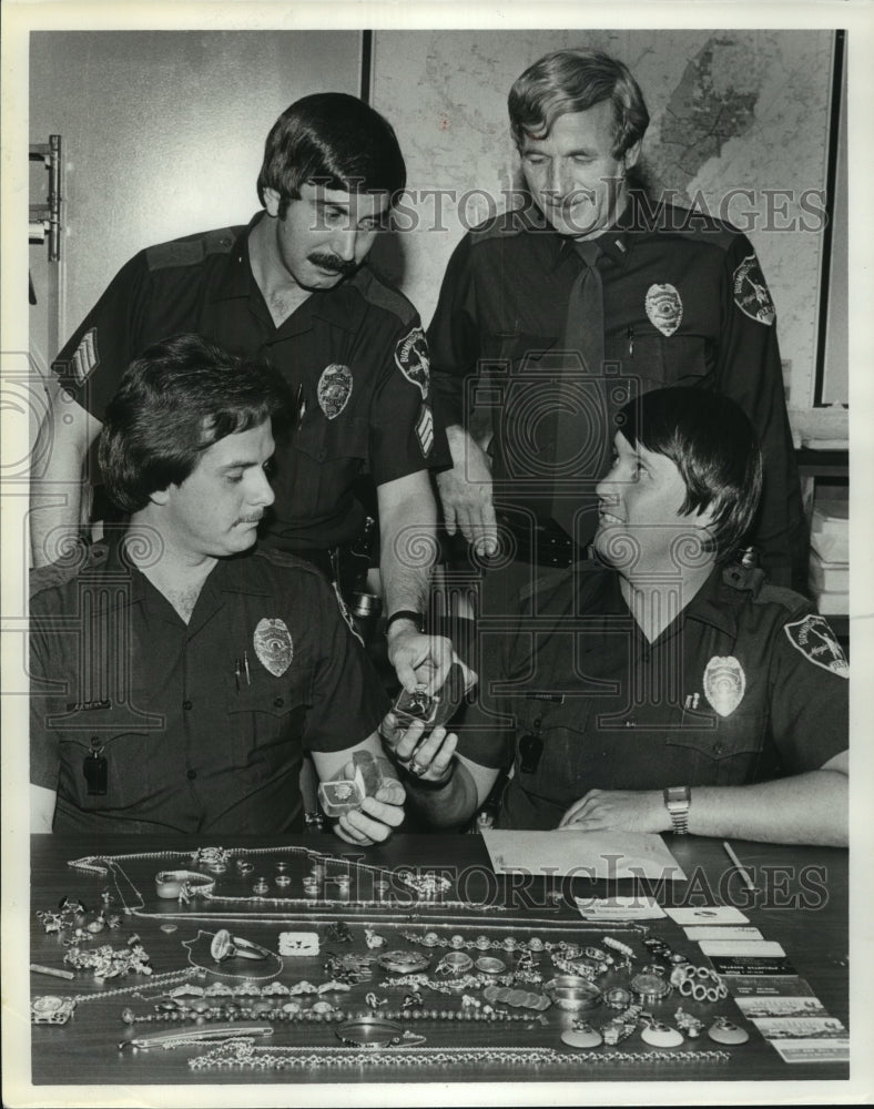 1979, North Precinct officers look over items stolen in robbery - Historic Images