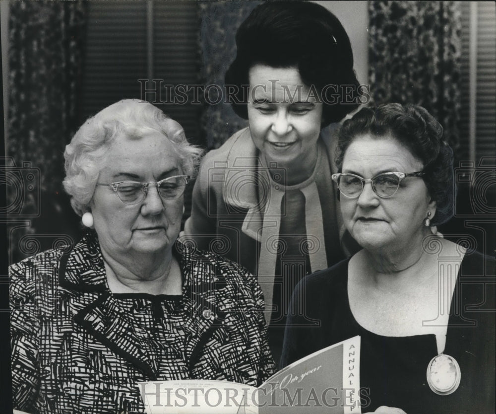 1967 Mrs. Harris Saunders &amp; two women, holding annual program - Historic Images