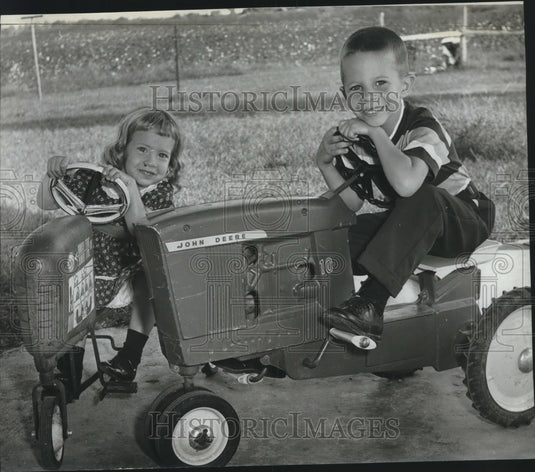 1963, Carol Ann & Jimmy Patterson on toy tractors, Madison County, AL - Historic Images