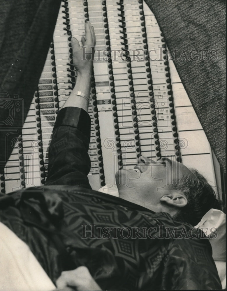 1966, Dr. Carl Robinson casts his vote in Bessemer from stretcher - Historic Images