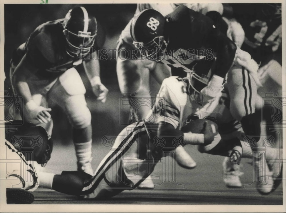 1987 Press Photo Alabama football player grabs mask of Miss. State ball carrier. - Historic Images