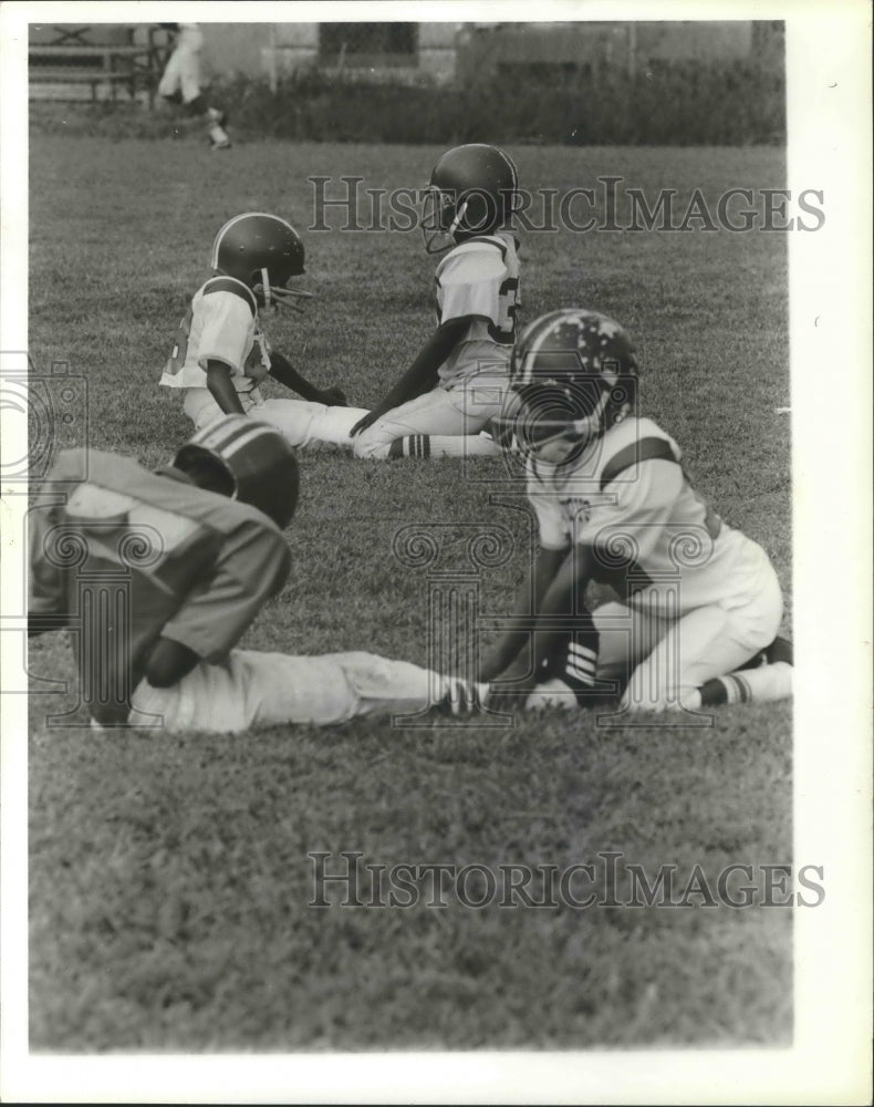1980 Young Football Players Help Each Other To Loosen Up To Play - Historic Images