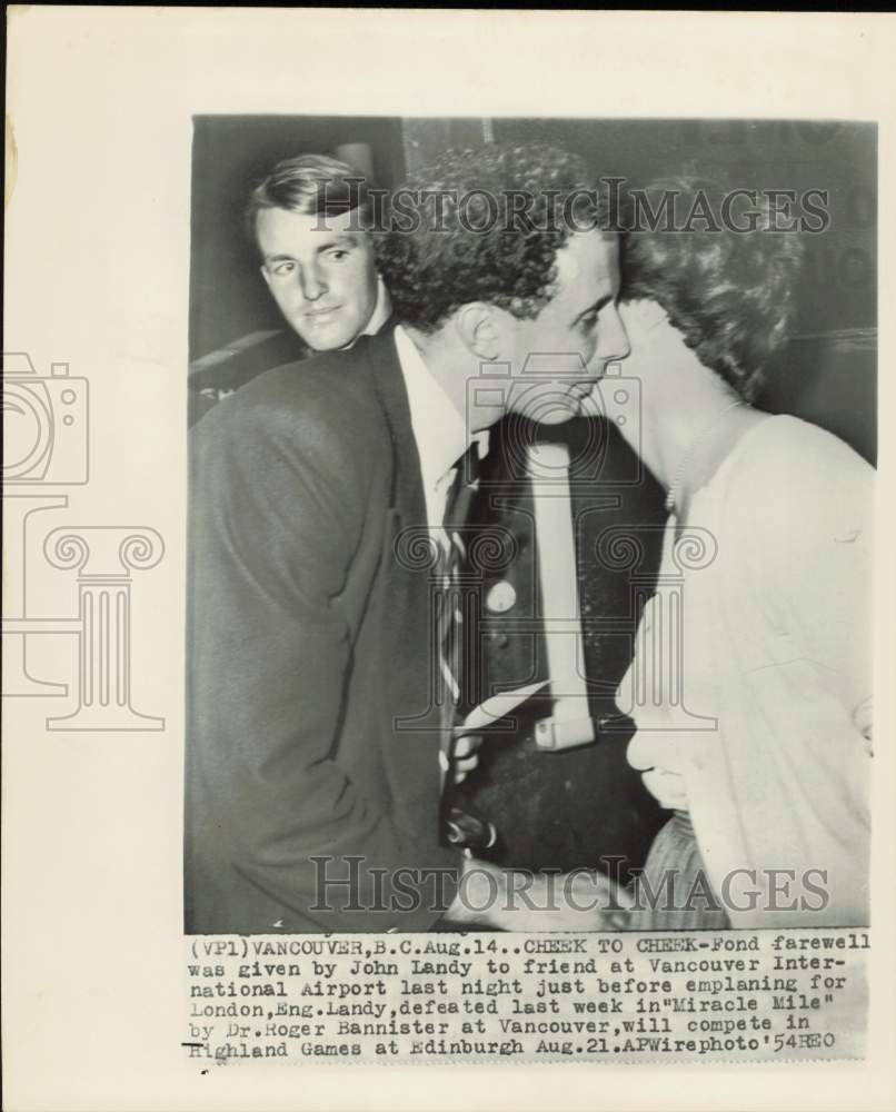 1954 Press Photo John Landy gives his cheek to friend at Vancouver Airport- Historic Images