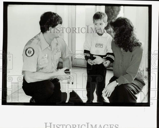 1992 Press Photo Paramedic Chris Vaughn talks with Rosemarie and Logan Cruz.- Historic Images
