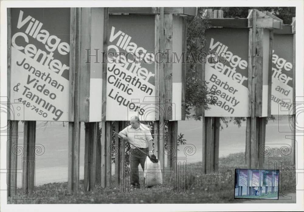 1988 Press Photo Village Center caretaker John Ahiquist cleans up around signs.- Historic Images