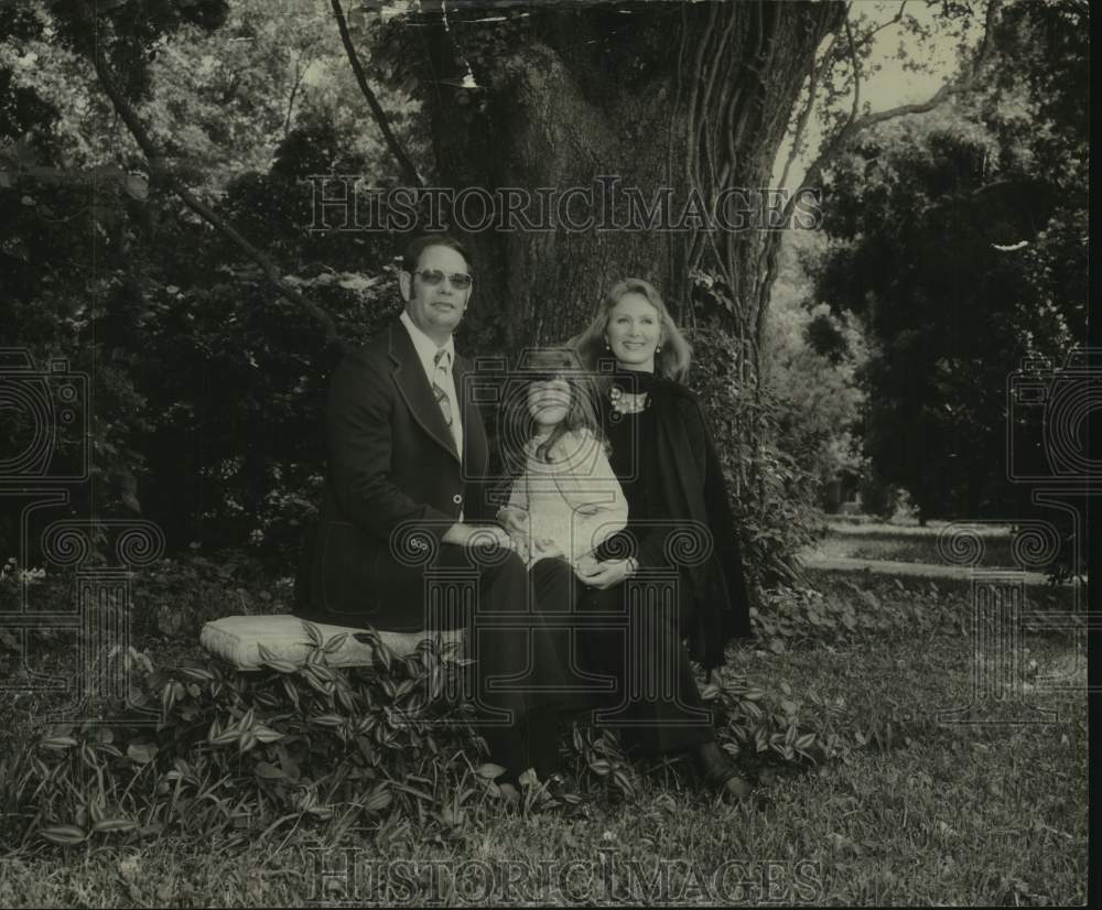 Roy Pike poses on bench with his wife & child, Mississippi - Historic Images