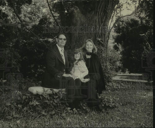 Roy Pike poses on bench with his wife & child, Mississippi - Historic Images