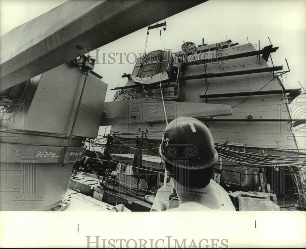 Man supervises ship construction at Ingalls Shipbuilding - Historic Images