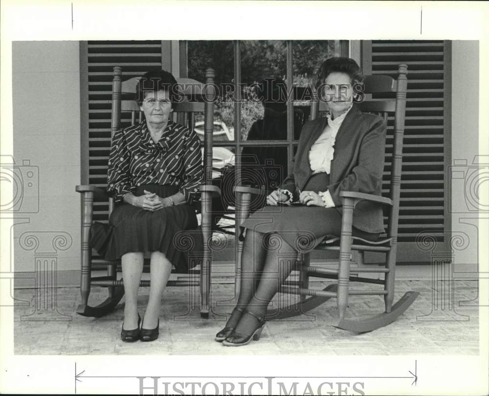 Women sit in rocking chairs on porch in Kirkland, Alabama - Historic Images