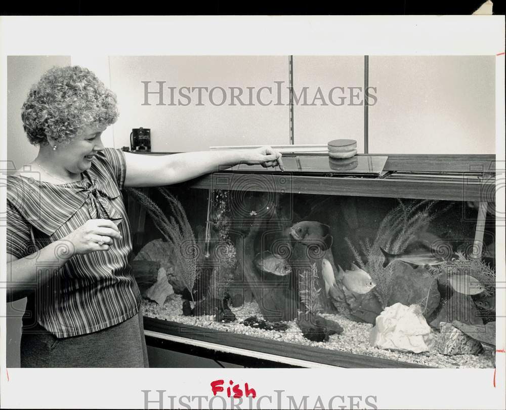 1986 Press Photo Patricia Falcione feeds Fish at Dun and Bradstreet Company - Historic Images
