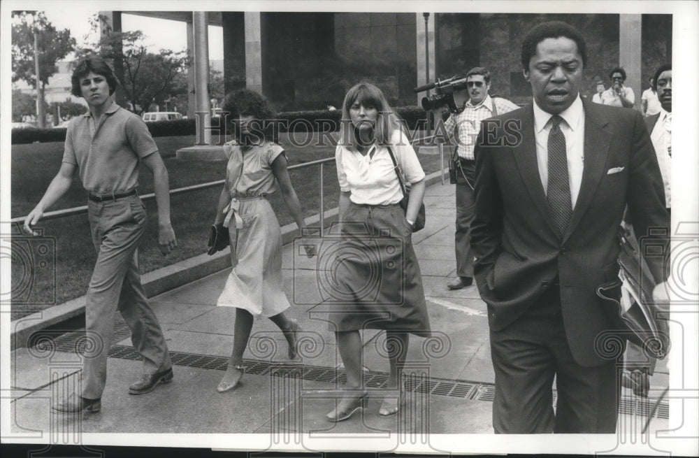 1982, John, Irene and Lydia looking on to Atty John Martin - Historic Images