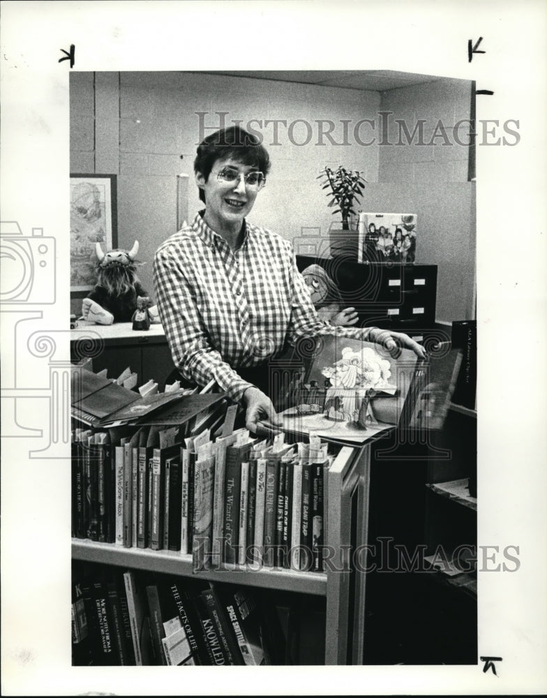 1984 Press Photo Margaret Galo Librarian picks books for Xmas - Historic Images