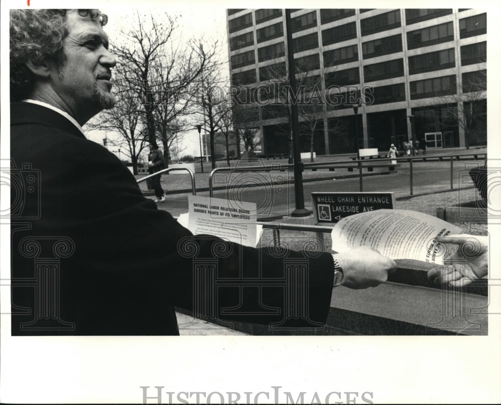 1980 Press Photo Aleck J. Halvorsen NLRB employee hands out leaflets. - Historic Images
