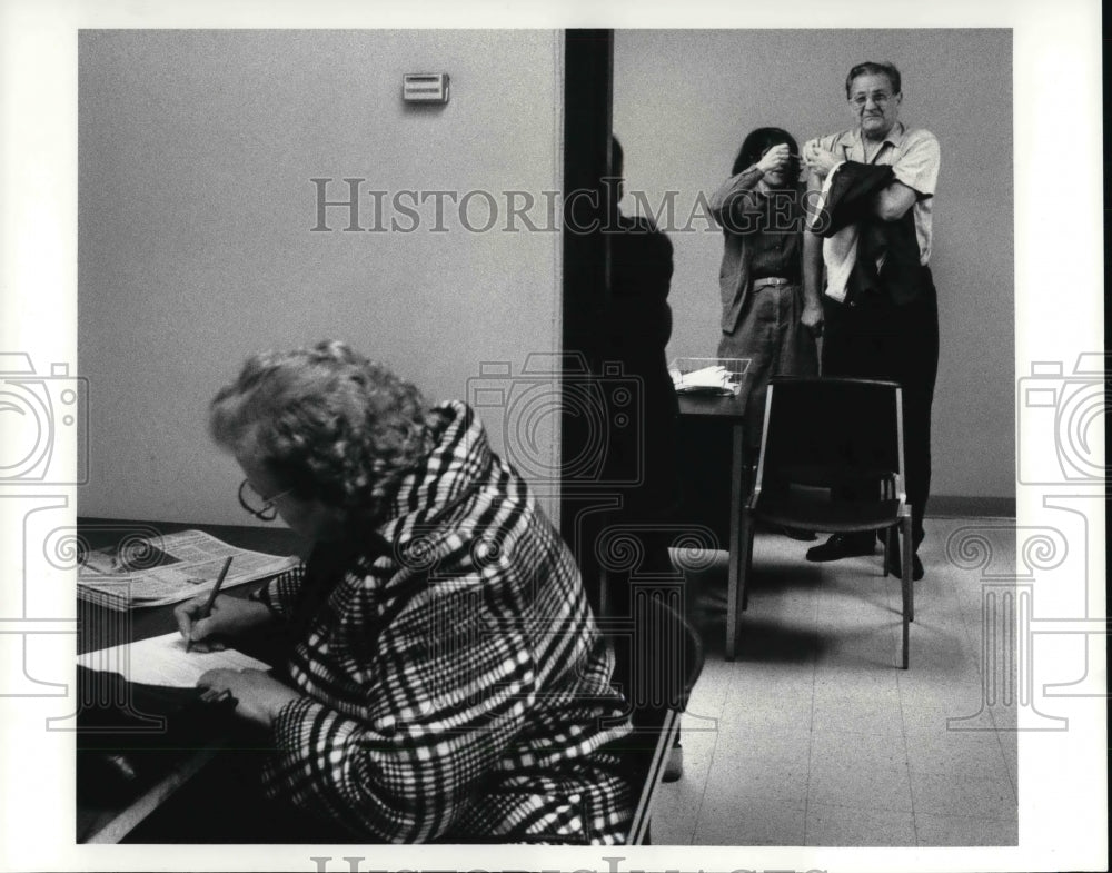 1986 Press Photo Elizabeth Zak, fills out form while Walter Luchka receives shot - Historic Images