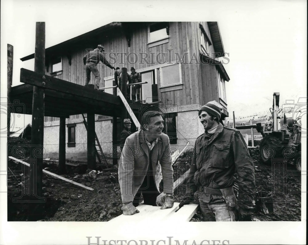 1972 Chat Huntley smiles with a construction worker  - Historic Images