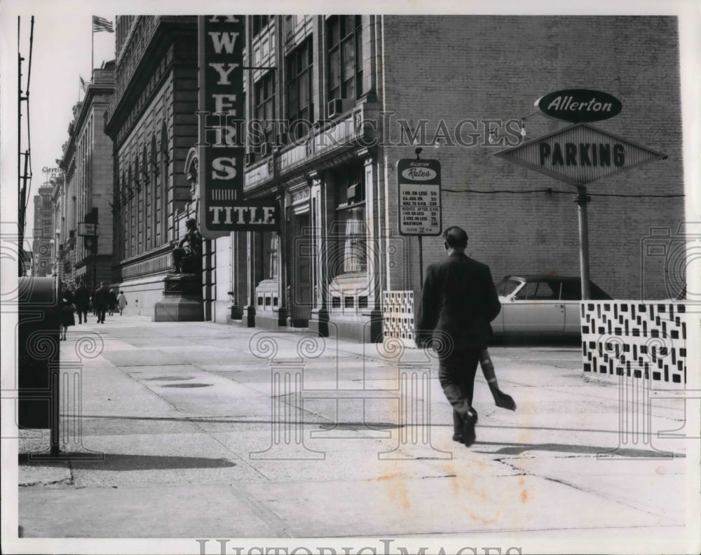 1964 Press Photo Man walking down Superior Ave carrying a rifle the day - Historic Images