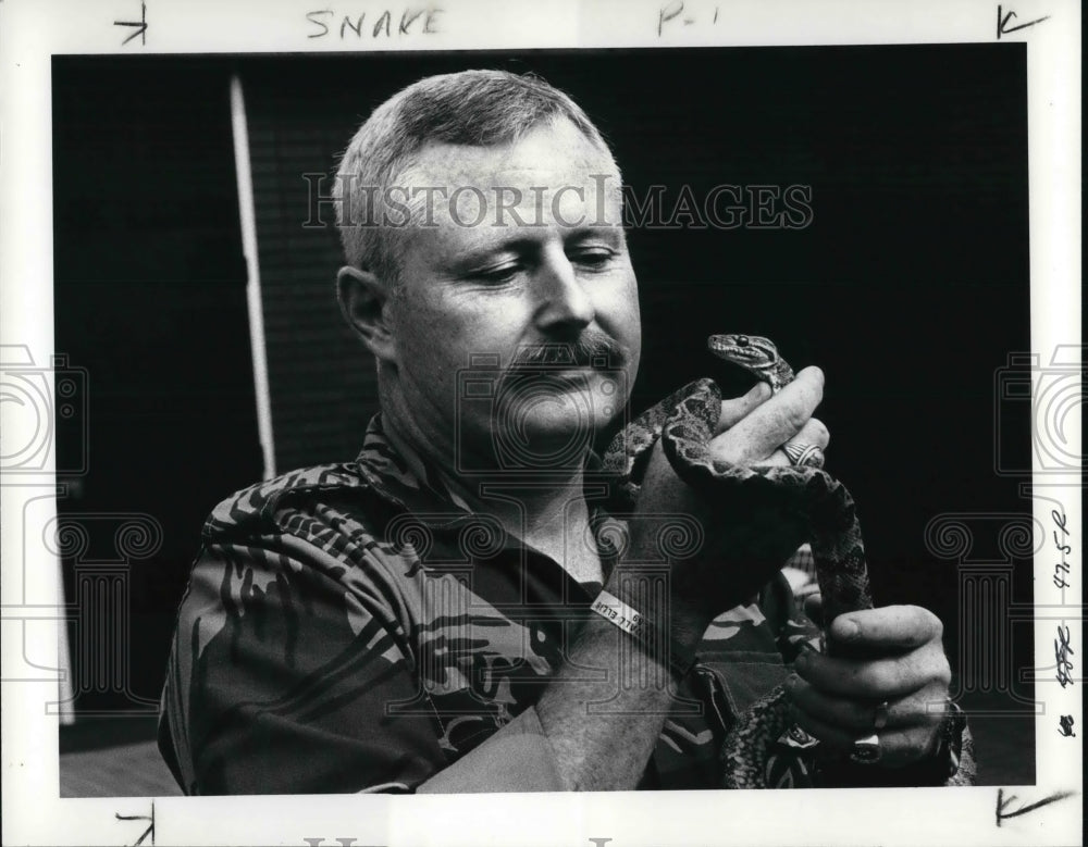 1986 Press Photo Lt. Gary Johnston holds a python he pulled out of a toilet - Historic Images