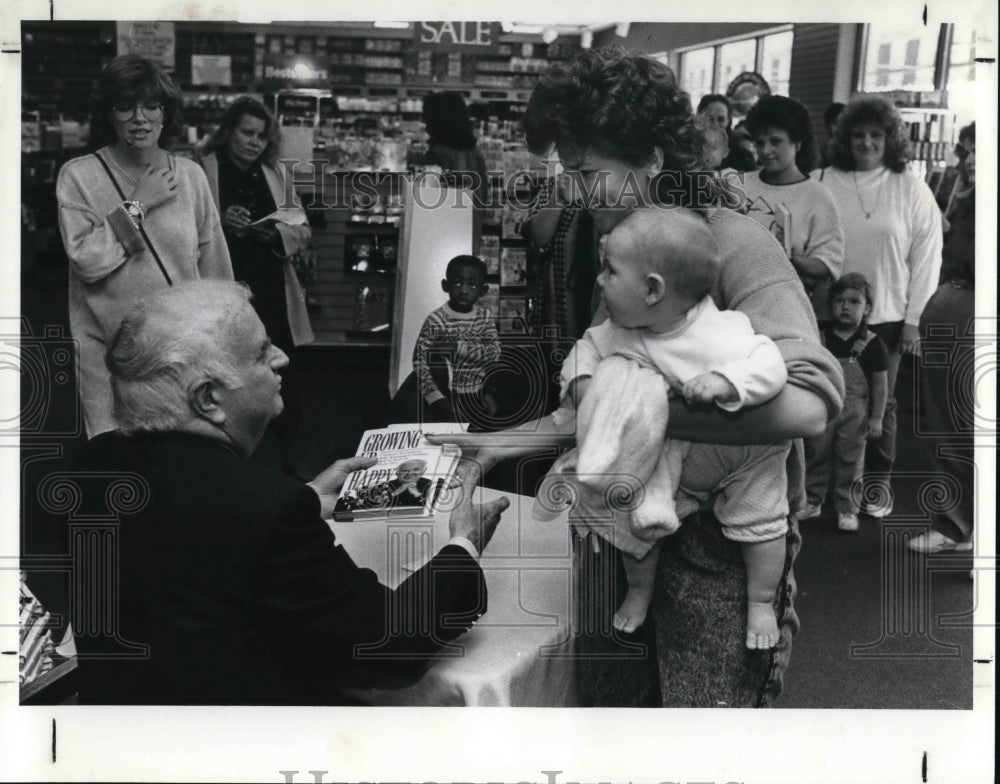 1989, Bob Keeshan, Capt Kangaroo, autographs his book - cva25934 - Historic Images