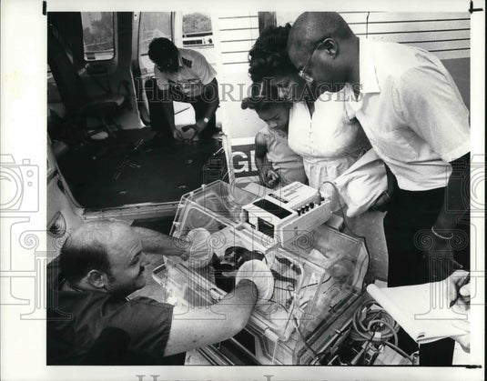 1988 Press Photo Bill Henry aiding baby to breath as mother Vannessa sees - Historic Images