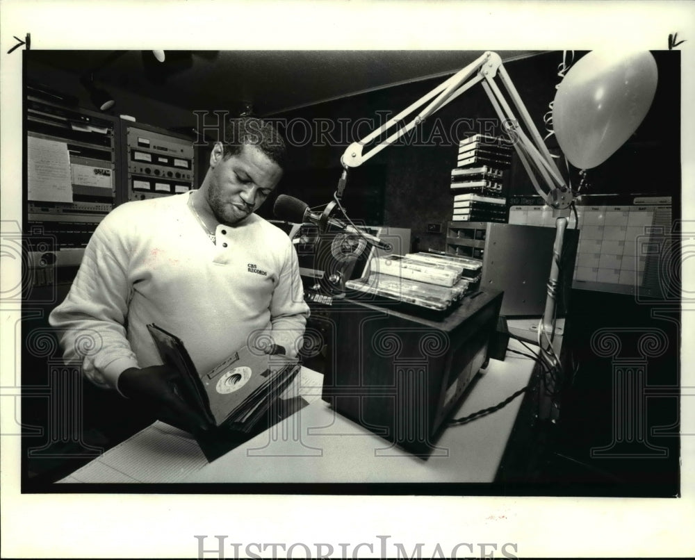 1985 Press Photo Lynn Tolliver sorts through some 45&#39;s on his 1st day back - Historic Images