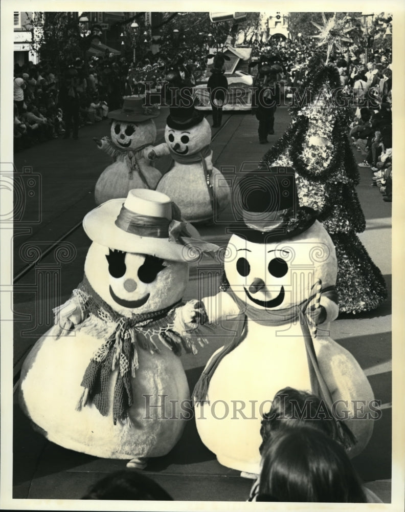 Press Photo Christmas delights - Dancing snow people, dressed for the winter-Historic Images