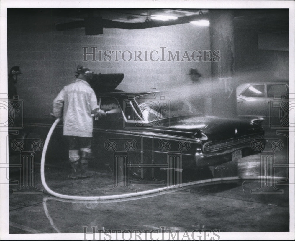 1970 The fireman puts out fire in the car at the school garage - Historic Images