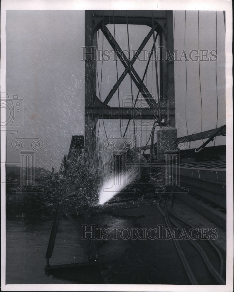 1970, Sparks fly as cutting torch bites into section of bridge deck - Historic Images