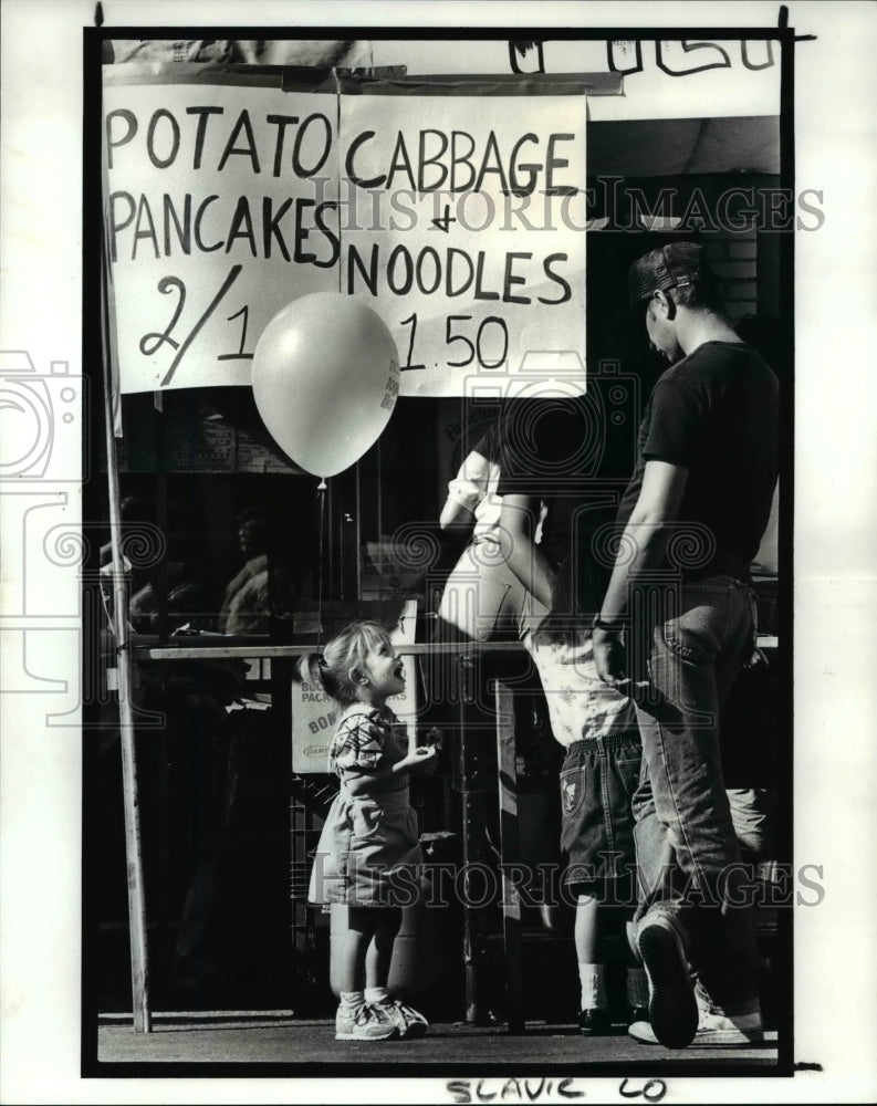 1987 Press Photo Three year old Amanda Plut waits at a food booth at the 10th-Historic Images